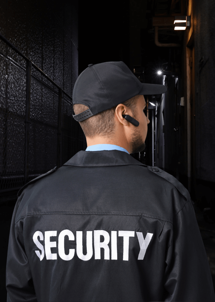 Security officer in uniform monitoring a dark alley during a night patrol